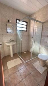 La salle de bains est pourvue d'une douche, d'un lavabo et de toilettes. dans l'établissement Casa da ilha em Florianópolis, à Florianópolis