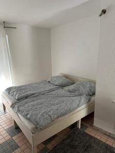 ein Bett in einem Schlafzimmer mit einer weißen Wand in der Unterkunft 2 Zimmer Wohnung Bruchsal (Monteurzimmer) in Bruchsal
