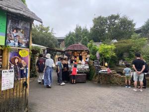 a group of people standing outside of a market at 湯布院 おやど花の湯yufuin oyado hananoyu in Yufu