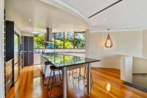 a kitchen with a large island with glass counter tops at Bayview Panorama - Paihia Holiday Home in Paihia