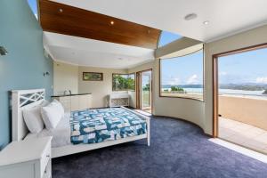 a bedroom with a bed and a view of the ocean at Bayview Panorama - Paihia Holiday Home in Paihia