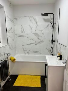 a bathroom with a white tub and a sink at Dunedin Heights in London