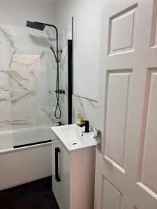 een badkamer met een witte wastafel en een douche bij Dunedin Heights in Londen