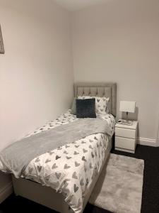 a bedroom with a bed and a white wall at Dunedin Heights in London