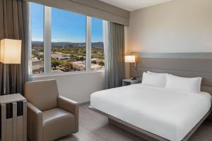 Habitación de hotel con cama y silla en AC Hotel by Marriott Beverly Hills, en Los Ángeles