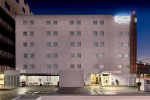 a large white building with a sign on it at City Express Junior by Marriott Toluca Zona Industrial in Toluca