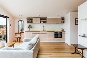 a living room with a couch and a kitchen at Studio Puriri, Vibrant, Artistic Studio in Raglan