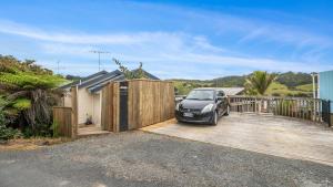 un'auto parcheggiata su una rampa di legno di fronte a una casa di Hibiscus Hideaway - Orewa Beach Holiday Home a Orewa