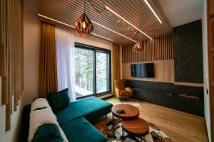 een woonkamer met een groene bank en een tafel bij Luxury Apartment 1984 in Bjelašnica