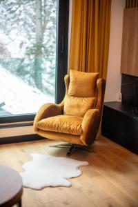een stoel in een woonkamer met een wit tapijt bij Luxury Apartment 1984 in Bjelašnica