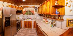 cocina con armarios de madera y nevera de acero inoxidable en Casa Rancho Verde, en Monterrey