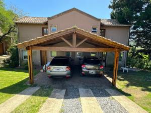 two cars parked in a garage in front of a house at Duplex al Golf Sierra de los Padres in Sierra de los Padres