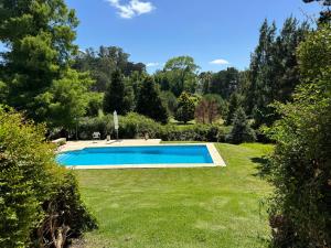a swimming pool in the middle of a yard at Duplex al Golf Sierra de los Padres in Sierra de los Padres