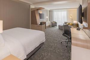 バーリントンにあるCourtyard by Marriott Burlington-Oakvilleのベッドとリビングルームが備わるホテルルームです。