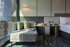 a hotel room with a bed and a table with a chair at Pullman Auckland Airport in Auckland