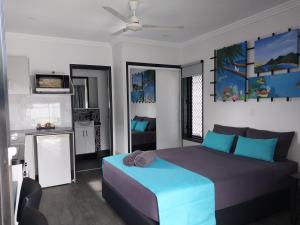 een slaapkamer met een blauw bed en een keuken bij The Dugongs' Rest in Horn