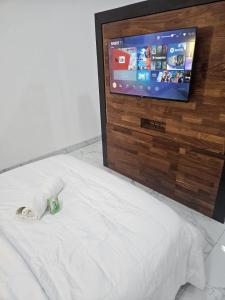 Una cama con TV encima. en Studio Le Cosi, Cotonou en Cotonú