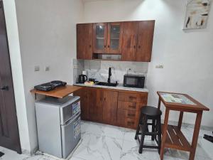 uma pequena cozinha com armários de madeira e uma mesa em Studio Le Cosi, Cotonou em Cotonou