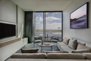 a living room with a couch and a tv at Pullman Auckland Airport in Auckland