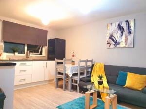 哈洛的住宿－Serviced Accommodation near London and Stansted - 2 bedrooms ，带沙发和桌子的客厅以及厨房。