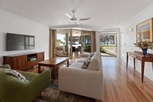 バイロンベイにあるWaterview Beachside Apartment - Palms 2のソファとテレビのあるリビングルーム