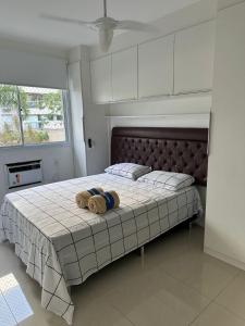 a bedroom with a bed with a stuffed animal on it at Excelente apartamento a 5 minutos da praia e shopping in Rio de Janeiro