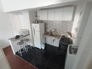 a small kitchen with a refrigerator and a sink at Leme in Rio de Janeiro