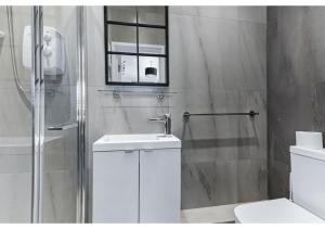 La salle de bains est pourvue d'un lavabo, de toilettes et d'une fenêtre. dans l'établissement Modern Apartment Where Everything Just Works!, à Londres