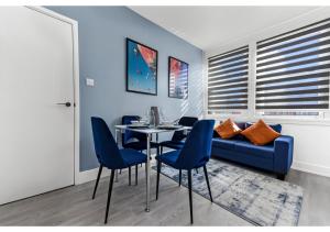 uma sala de jantar com um sofá azul e uma mesa e cadeiras em Modern Apartment Where Everything Just Works! em Londres