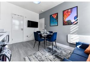 - un salon avec une table et un canapé bleu dans l'établissement Modern Apartment Where Everything Just Works!, à Londres
