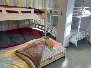 a bedroom with two bunk beds and a bed with a pillow at 小布施のあたり in Obuse