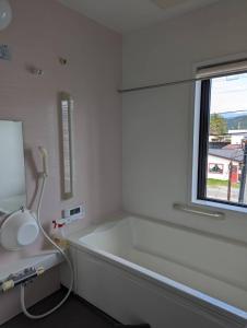 bañera blanca en una habitación con ventana en 小布施のあたり, en Obuse