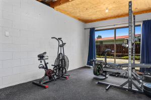 a gym with two treadmills and two bikes at Heavenly on Riverside - Whakatāne Holiday Home in Whakatane