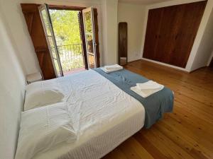 ein großes Bett in einem Zimmer mit Fenster in der Unterkunft Casa do Reguengo (New!) in Castelo de Vide