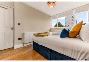 um quarto com uma grande cama branca com almofadas amarelas em Stunning Family Home - Sleeps 11 em Londres