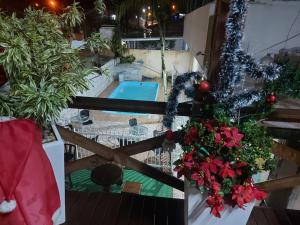 balcón con piscina y decoración navideña en Pousada Ilha do Itacolomi, en Penha