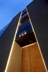 ein Gebäude mit einer Uhr auf der Seite in der Unterkunft Hotel DUO kinsicho in Tokio