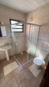 La salle de bains est pourvue d'une douche, de toilettes et d'un lavabo. dans l'établissement Casa da ilha em Florianópolis, à Florianópolis