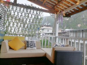 un divano bianco su un balcone con vista di Lazzy inn a Yangshuo