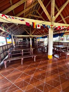 uma sala com mesas e bancos num edifício em Cabaña privada en las islas de Guna Yala Isla icodub em Achoertupo