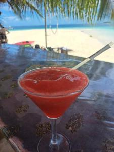 Achoertupo的住宿－Cabaña privada en las islas de Guna Yala Isla icodub，坐在海滩旁的桌子上喝一杯