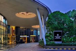 um grande edifício com uma placa em frente em Sheraton Grand Jakarta Gandaria City Hotel em Jakarta