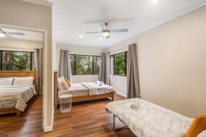 a bedroom with two beds and two windows at Cockatoo Hideaway- Cabin in Montville