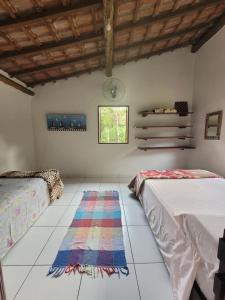 um quarto com duas camas e um tapete no chão em Casa da Jane em Paraty
