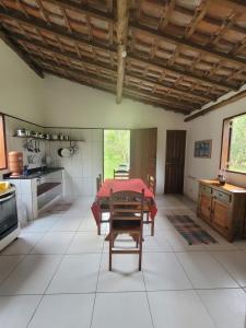 uma grande cozinha com uma mesa vermelha em Casa da Jane em Paraty