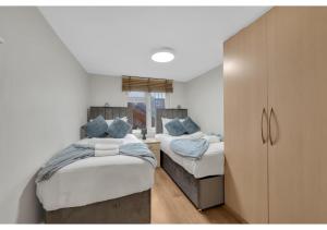 sypialnia z 2 łóżkami i niebieskimi poduszkami w obiekcie Relaxing 1BR Flat - Cozy and comfortable w Londynie