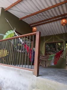 un porche con una valla y una hamaca en Sierra Kay Hostel, en Guachaca