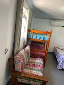 Zimmer mit Sofa, Bett und Fenster in der Unterkunft Pedacinho do céu in Cabo Frio