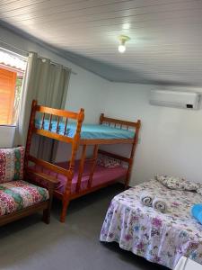 ein Zimmer mit zwei Etagenbetten und einem Bett in der Unterkunft Pedacinho do céu in Cabo Frio