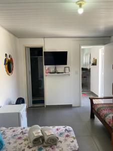 a living room with a bed and a television at Pedacinho do céu in Cabo Frio